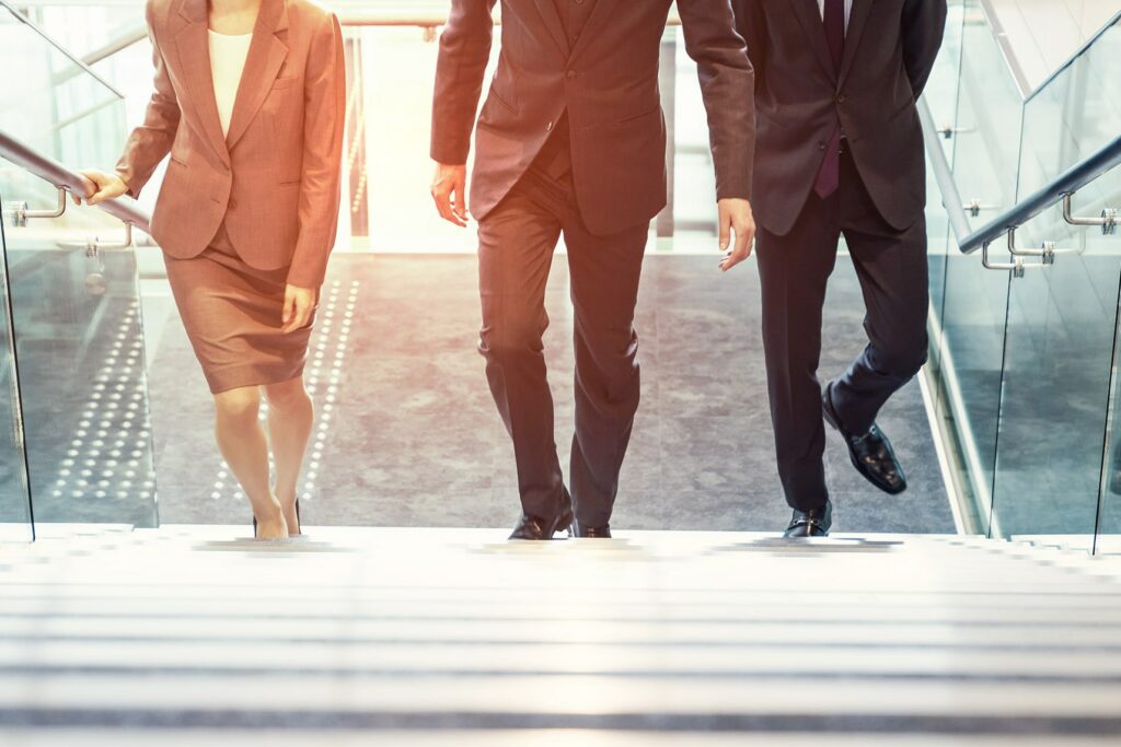 Geschäftsfrau und Geschäftsmänner gehen gemeinsam eine Treppe hinauf