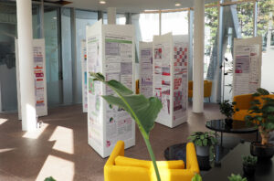 Infosäulen der Wanderausstellung Pfad der Vielfalt mit bunten Grafiken mit Pflanzen in einer Lobby