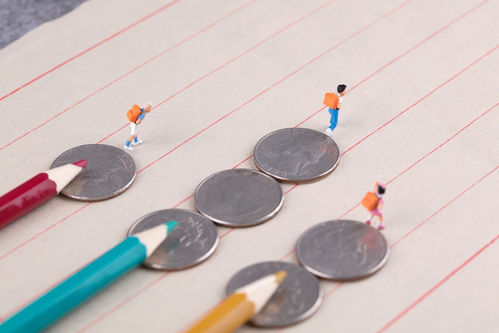 Unterschiedliche ökonomische Startpunkte im Leben werden durch drei Figuren und Münzen dargestellt.